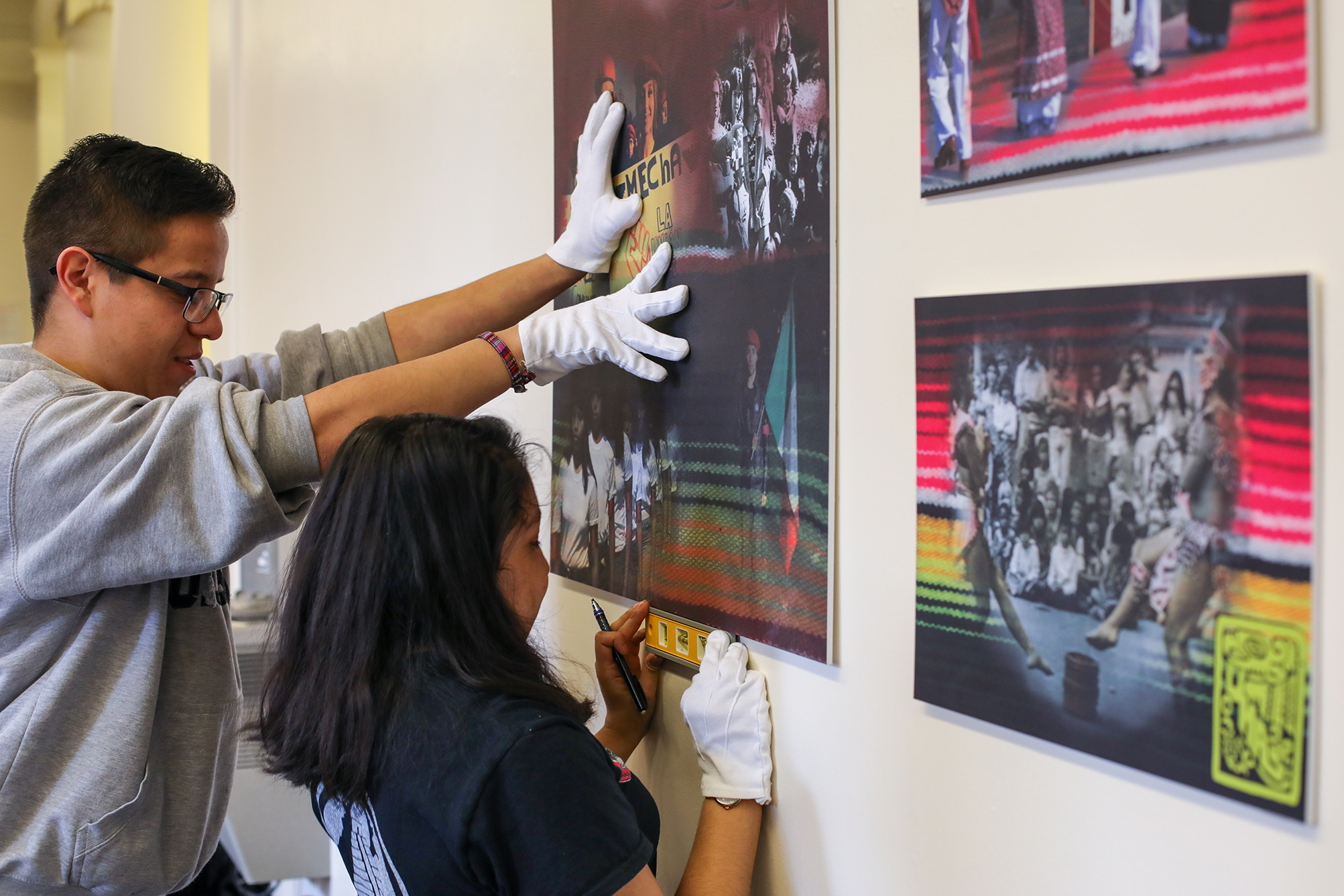 Students placing art on the wall