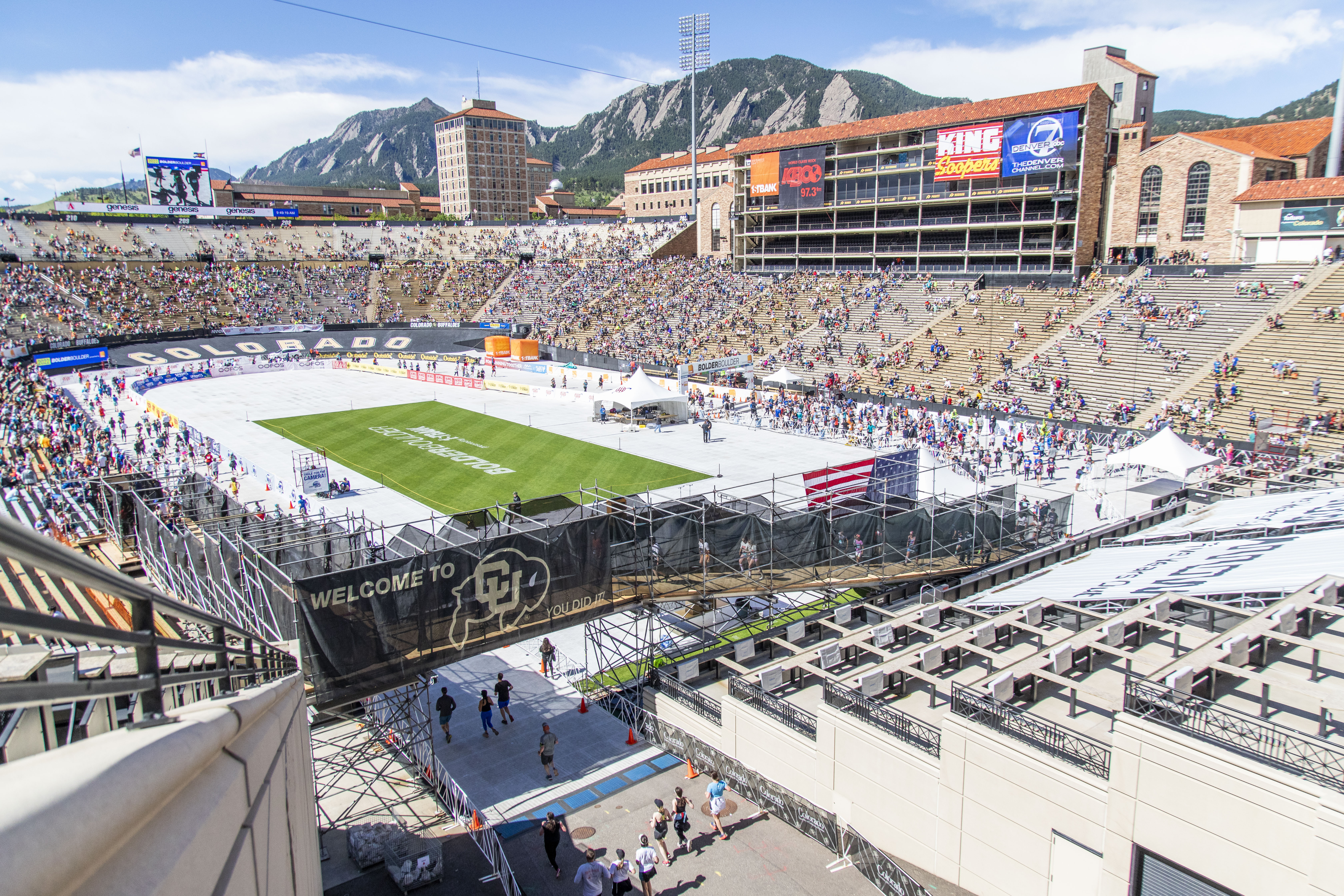 People fill Folsom Field, with the Flatirons in the background, for the culmination of the Bolder Boulder 10K race in 2022 (Photo by Justin Hein/University of Colorado)