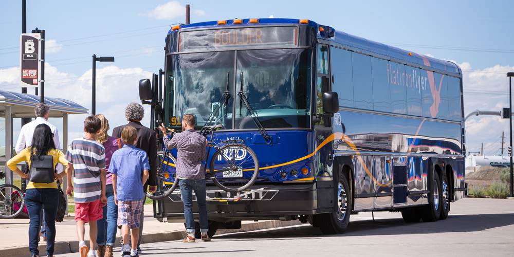 Passengers wait to load RTD bus