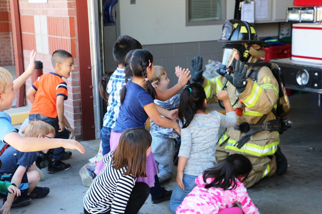 Children engage with a fire fighter.
