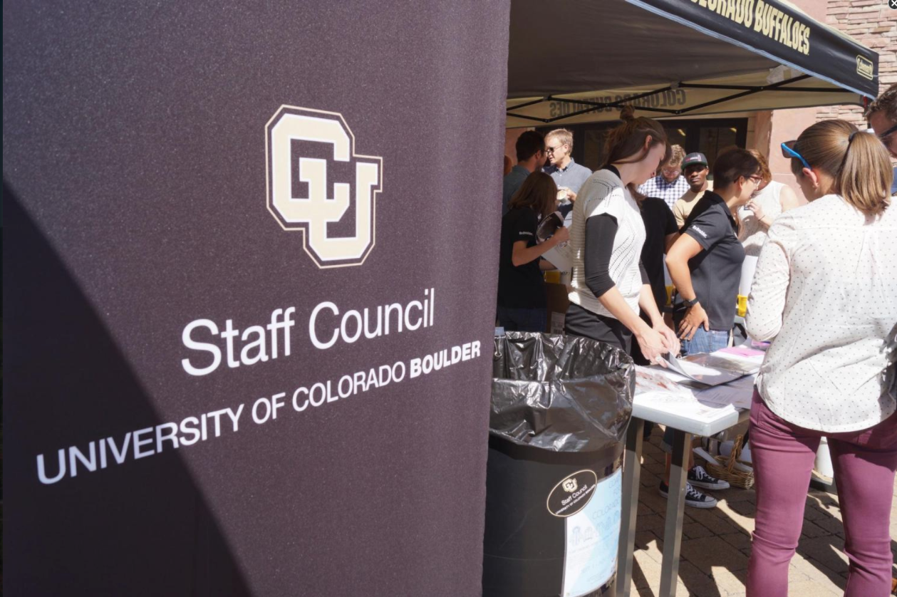 A standing Staff Council banner next to an outdoor info booth.