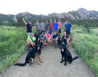 A group of people and two dogs on a trail. 