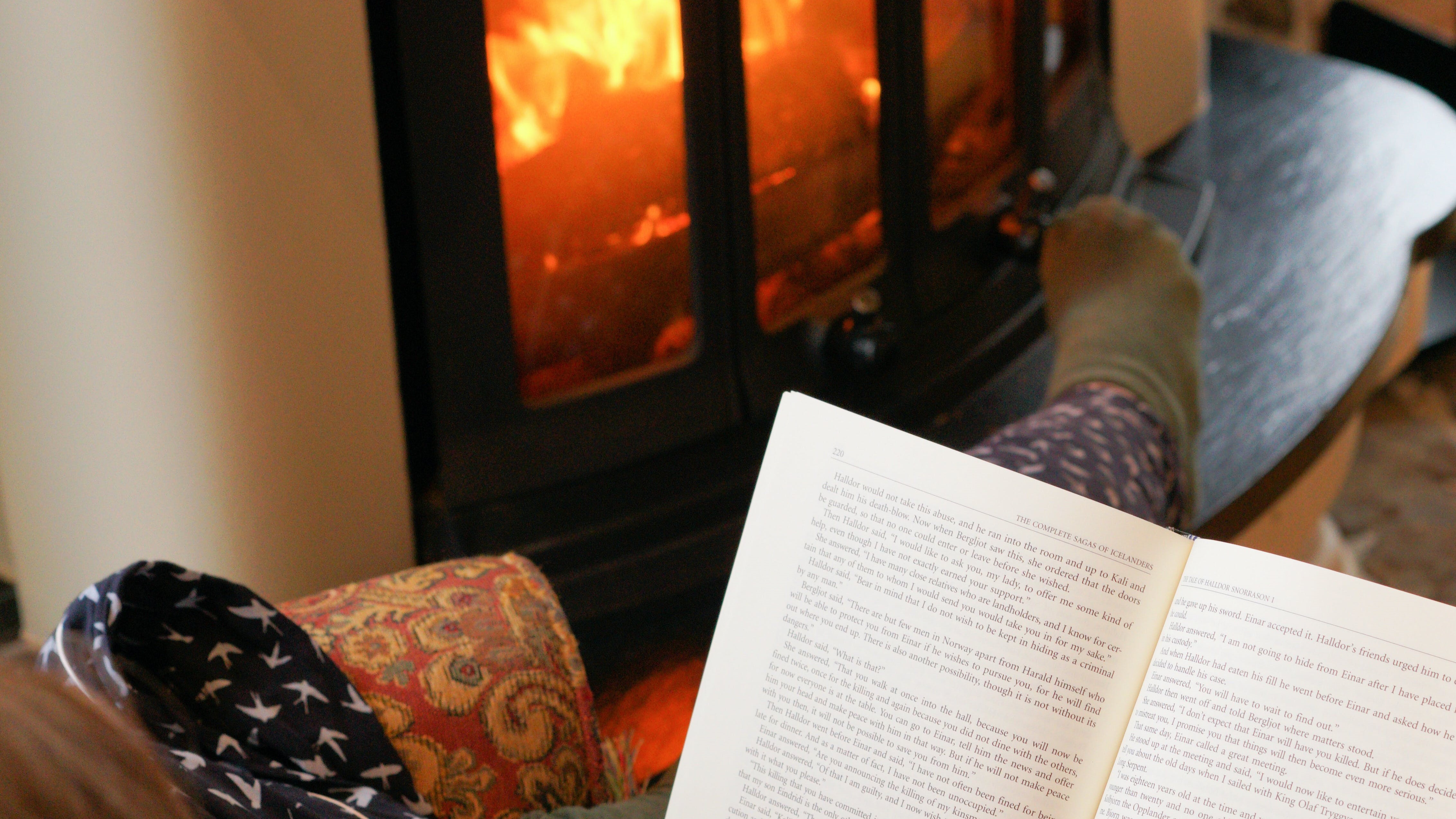 Person reading by fire.