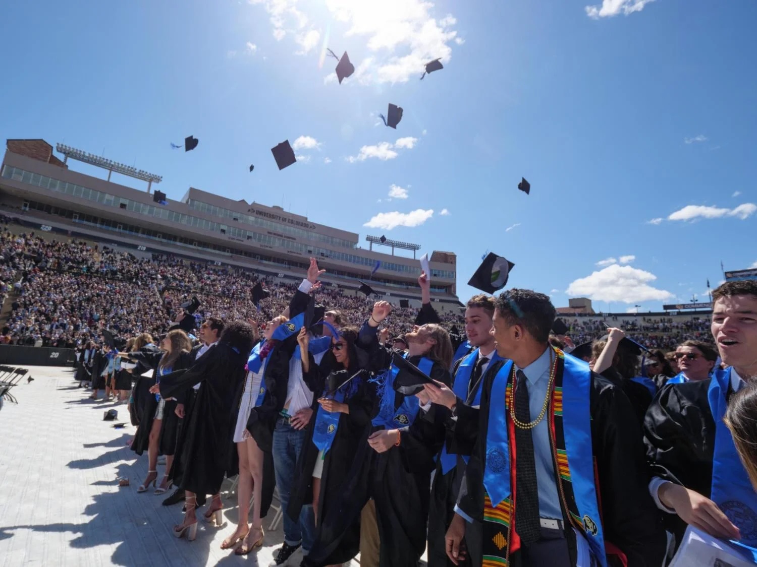 Students tossing their graduation caps during the University of Colorado commencement ceremony.