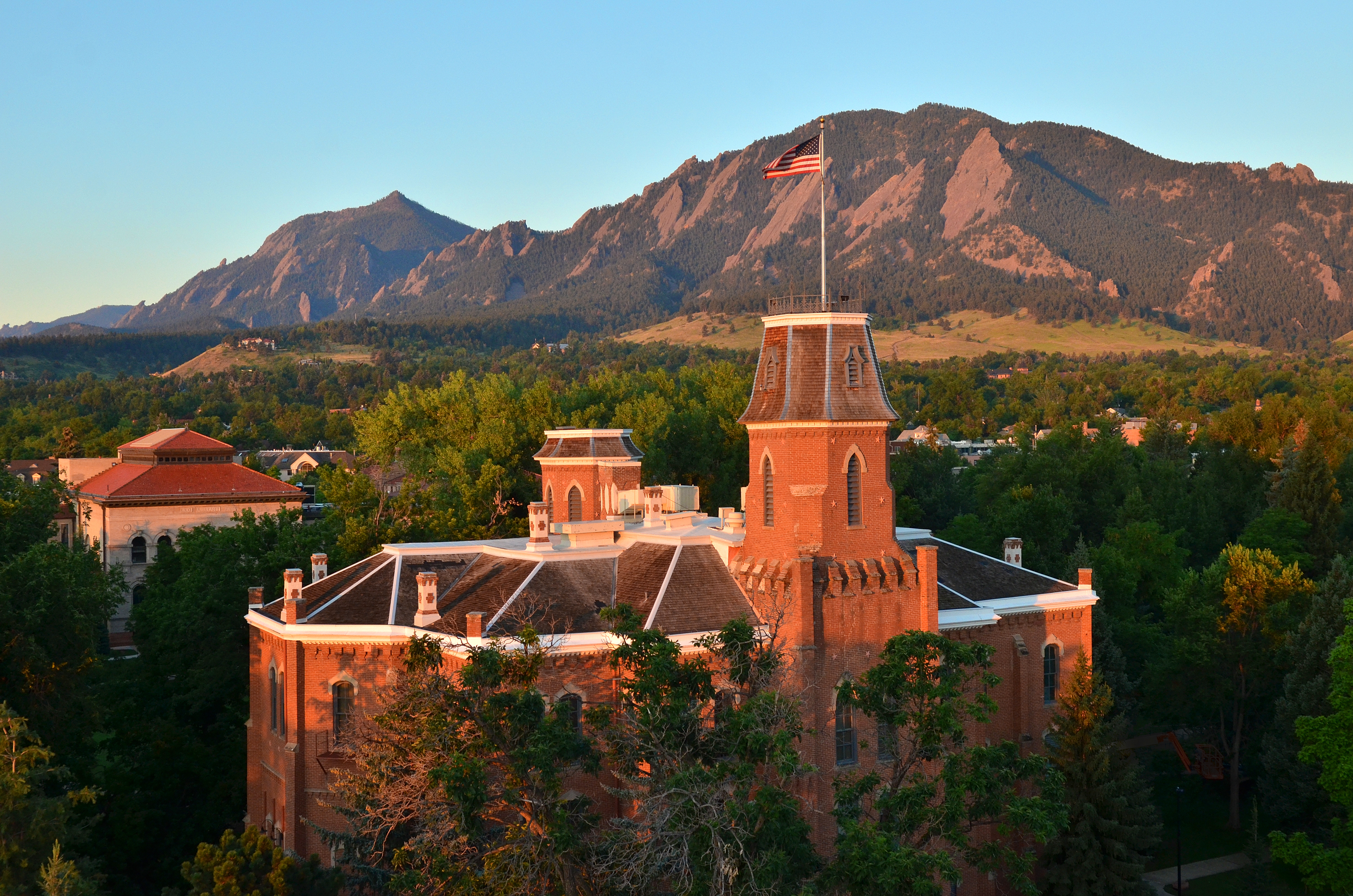 Old Main on CU Boulder campus and Flatirons at sunset
